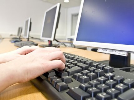 hands typing on keyboard in front of a computer screen