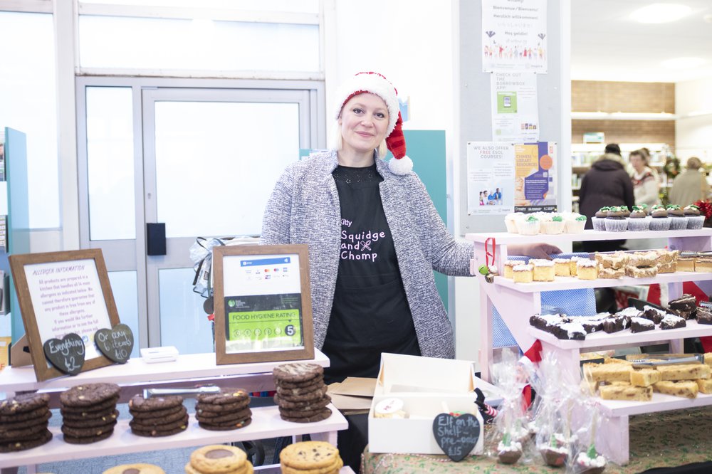 Kitty Clifford stood behind her stall at Sutton in Ashfield Library's market with cakes, blondies and brownies on display.