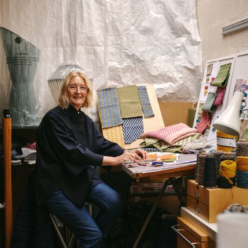 Designer Jane Withers sitting at her desk in her design studio