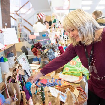 Customer browsing stalls, reaching out to look at gifts