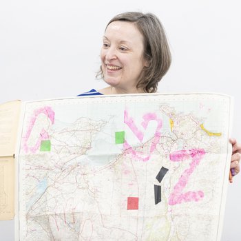 Artist holding up a large map