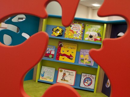 A shelf of board books, visible through a splat-shaped cut out