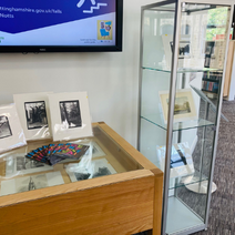 A cabinet and table displaying old photos in a gallery