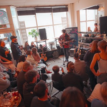 A room full of people watching a music performance