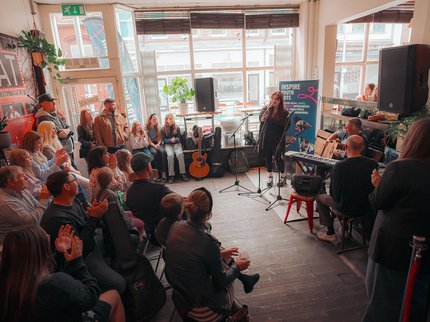 A room full of people watching a singer