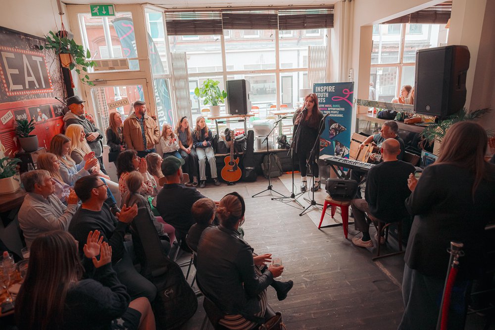 A room full of people watching a singer