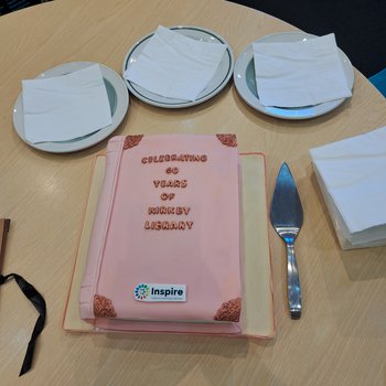A close up image of a cake shaped like a book