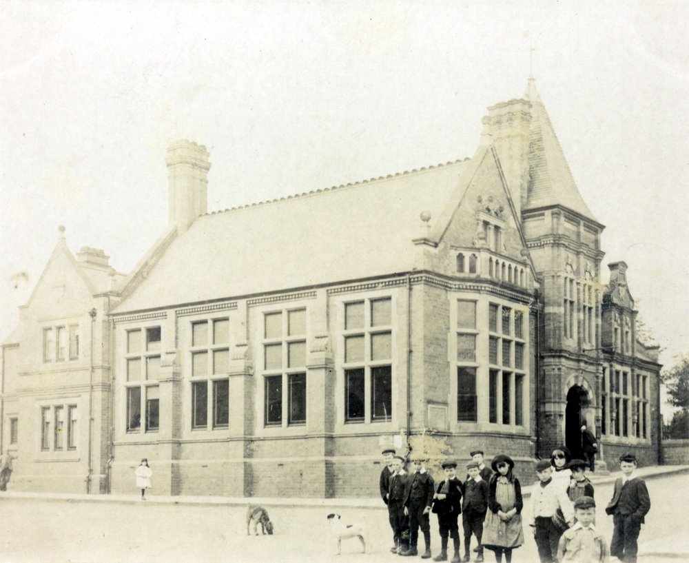 Black and white photograph of Hucknall Library with children and dogs in foreground