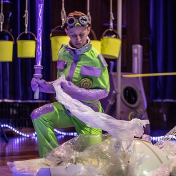 Actor dressed for outer space with buckets in the background.