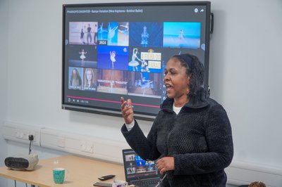 Dr Bourne presenting in front of a smart screen.