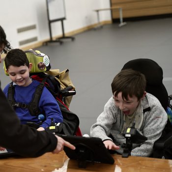 Photo of two young males of school age, taking part in an AO music session with a music tutor.