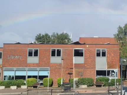 exterior of Arnold Library with a rainbow in the sky