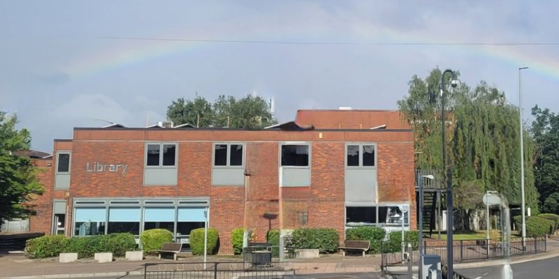 exterior of Arnold Library with a rainbow in the sky