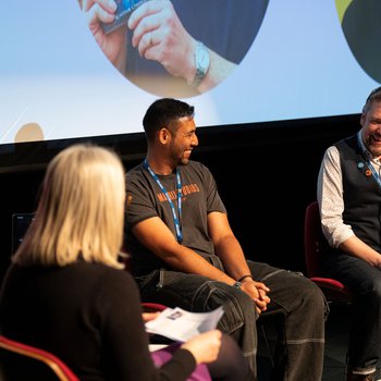 Two authors sit on stage with an interviewer