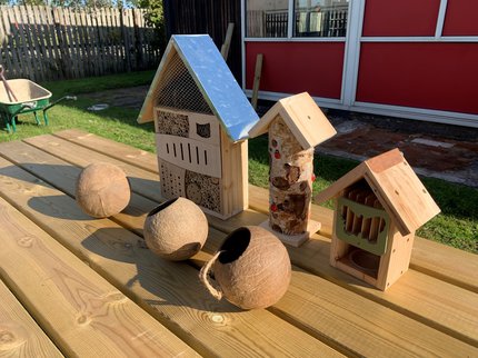 three wooden houses acting as garden habitats for wildlife