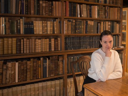 Author Blessin Adams sitting at a table.
