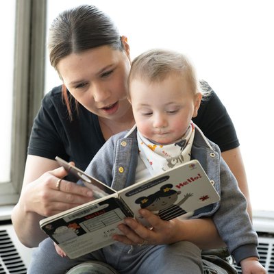 A mum and her baby are reading together.