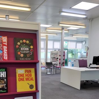 Image showing Burton Joyce Library, with the help desk in the background and cookbooks on display in the foreground