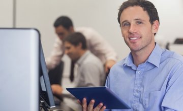 man sat at desk holding tablet ready for teaching