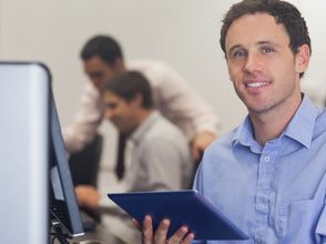 man sat at desk holding tablet ready for teaching