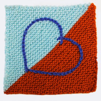 A picture of a knitted square with an embroidered heart motif worked in chain stitch