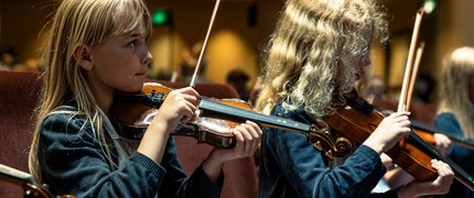 A young girl plays violin