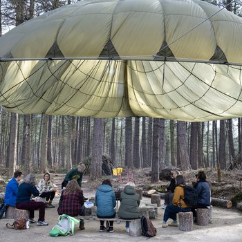 A group of people standing around a water bowl, one dressed in victorian clothing