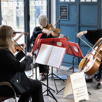 A woman in a grey top smiling and sitting a table