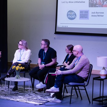 A man in a grey hoodie and blue cap raps