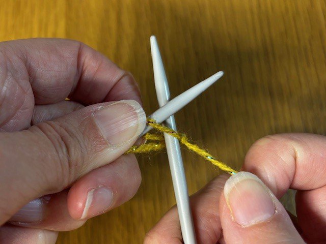 Image of a knitting needle going through the first stitch