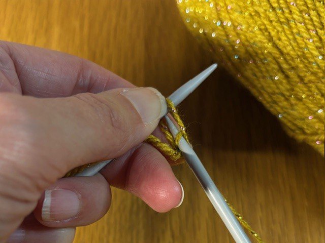 Photo of right-hand needle going back through first stitch