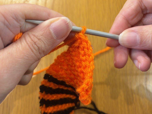 Only one stitch left on the knitting needle while the rest have been cast off