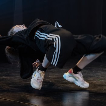 A street dancer bending backwards performing on stage