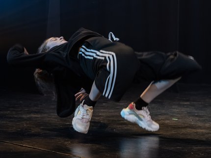 A street dancer bending backwards performing on stage