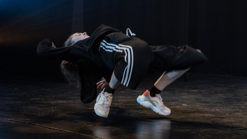 A street dancer bending backwards performing on stage