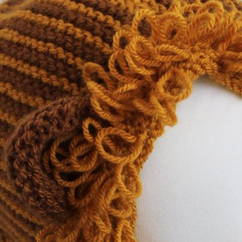 Knitted squares with green wool and knitting needles