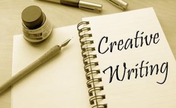notebook open with quill and ink and text that reads creative writing