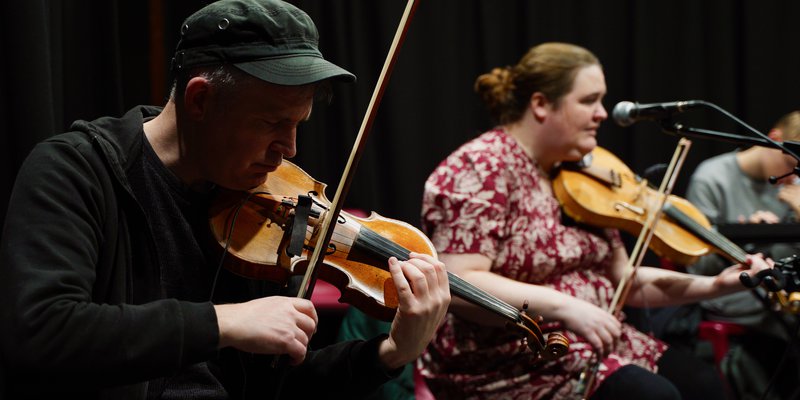 Photo of a male Able Orchestra musician playing a violin.