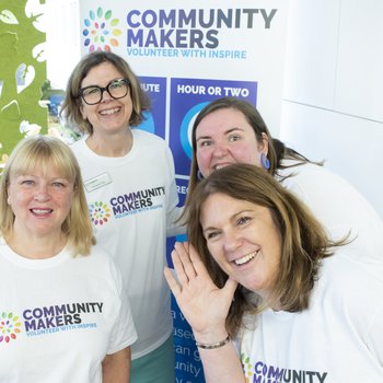 4 people wearing Community Makers t-shirts, smiling at the camera.