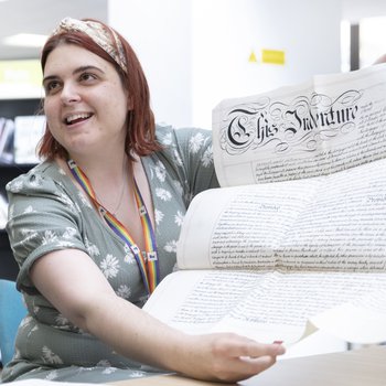 A woman unfurls a historical document