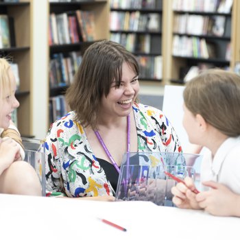 Author Alice speaking to two children sat at a table.