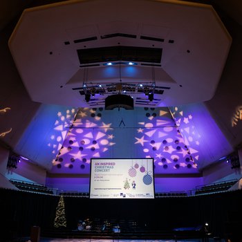 A view of the stage and theatre seating at Royal Concert Hall, with Christmas graphics on the walls