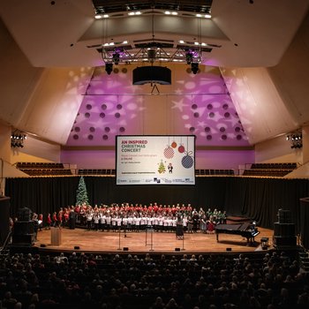 All the school choirs stand on stage with a view of the auditorium