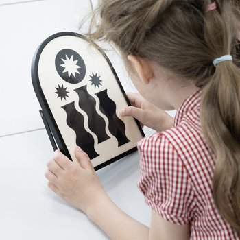 School child looking at a framed piece of artwork