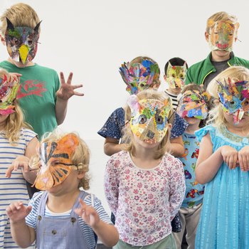 A group of children wearing masks they have made.