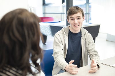 A teenage boy talking to a teacher