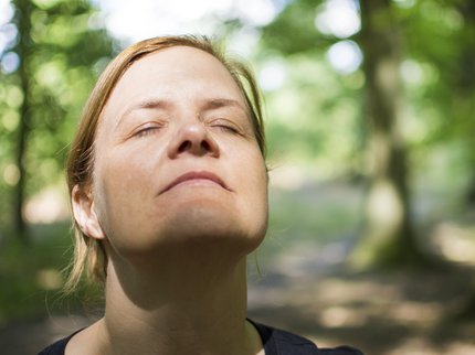 Woman with eyes closed in forest