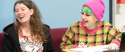 Two Inspire College students laughing in class.