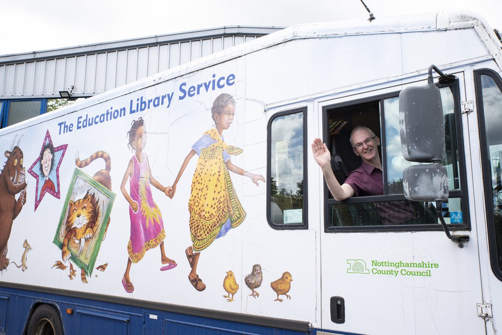 A man waves from the mobile book van