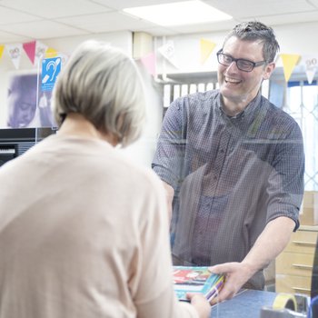 Education Library Service assistant serves a customer